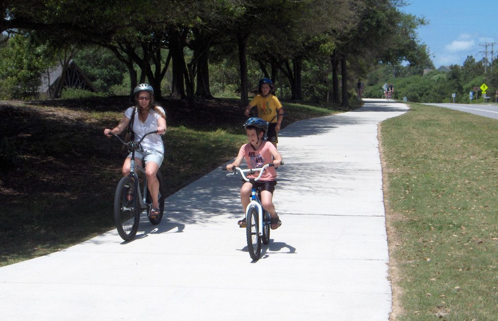 A family riding bikes along a path.