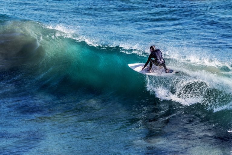 A surfer in a wetsuit riding a wave.